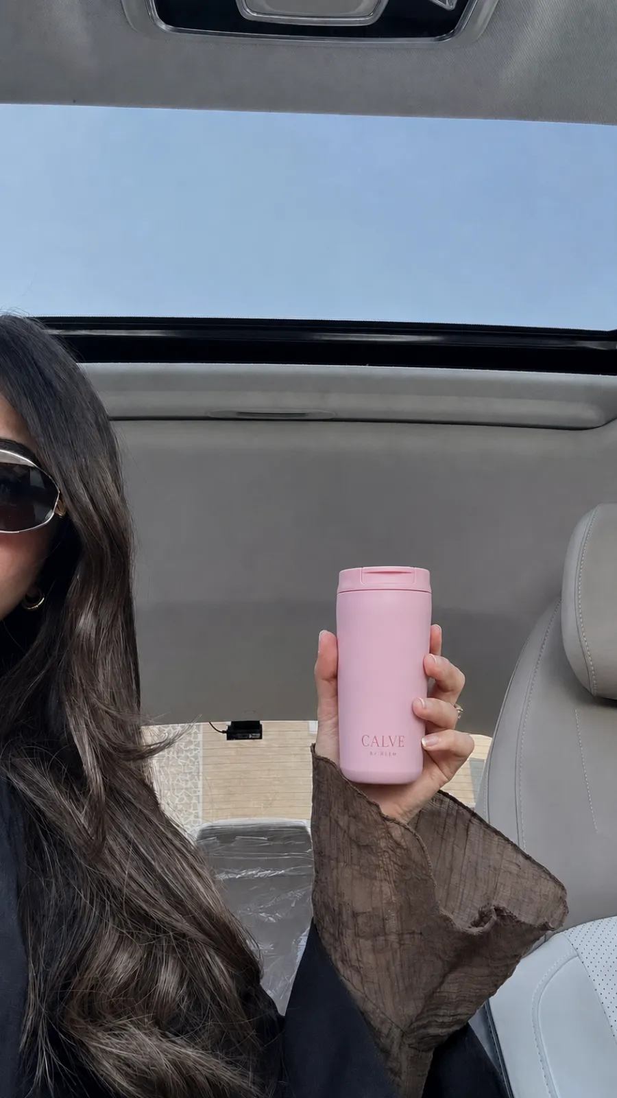 CALVE pink tumbler carried on a sunny drive