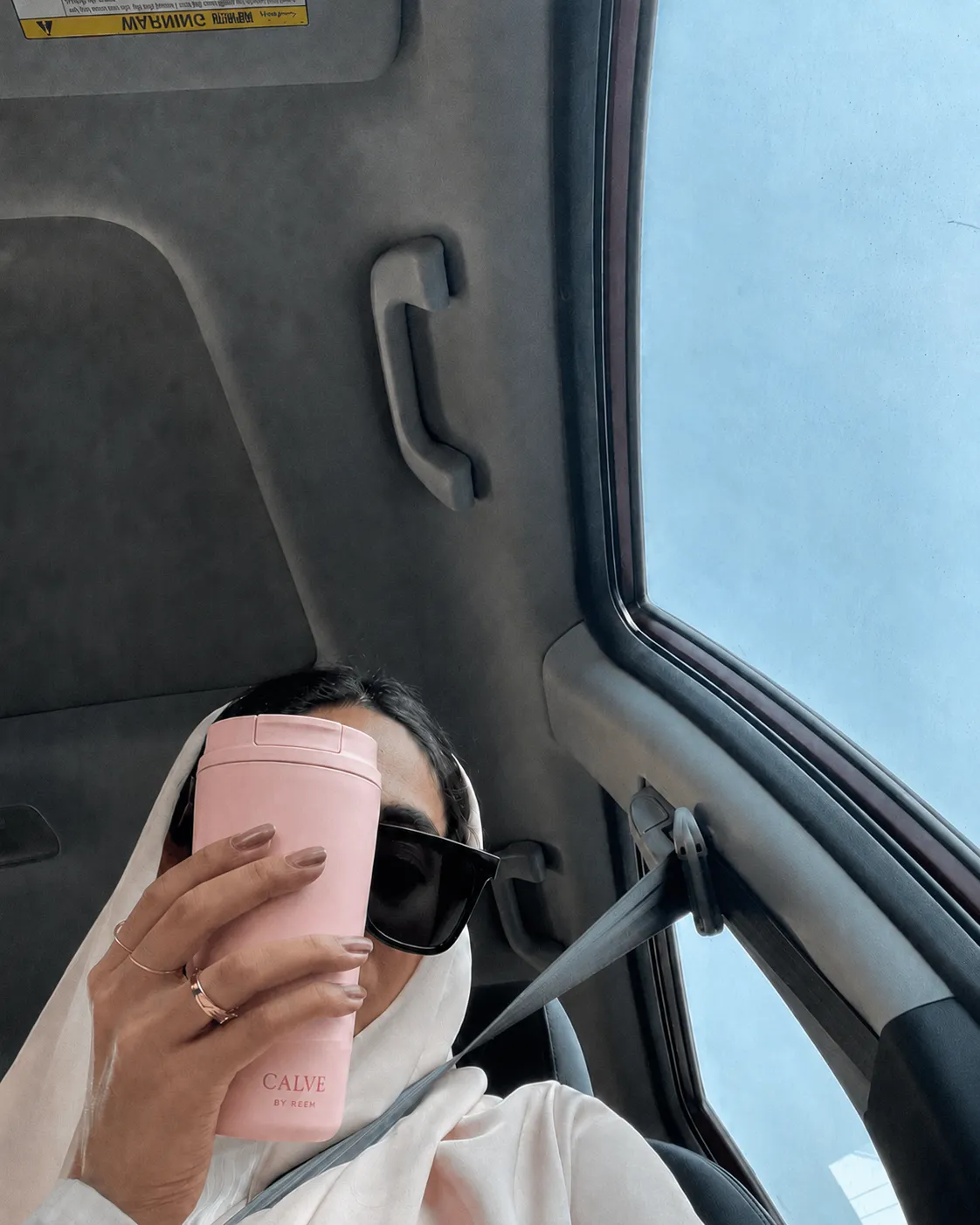 CALVE pink tumbler on a bright daytime drive