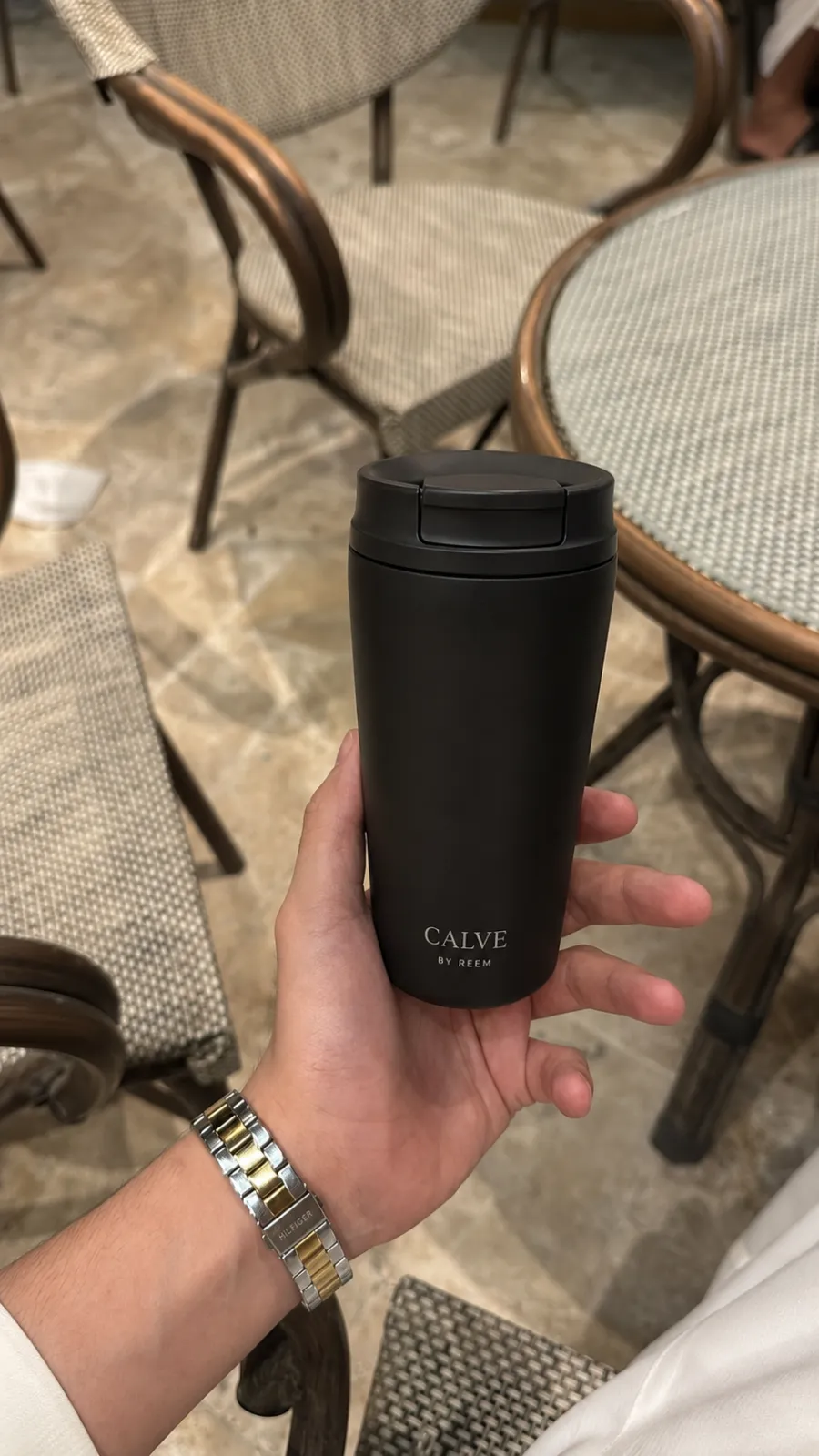 CALVE black tumbler at a café